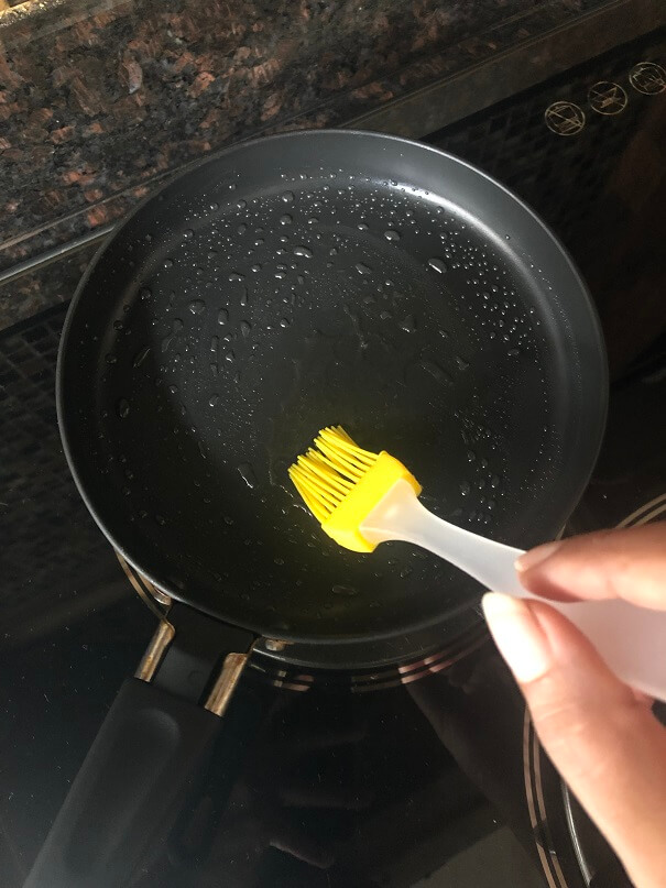 Dip the brush in the oil and brush the pan lightly